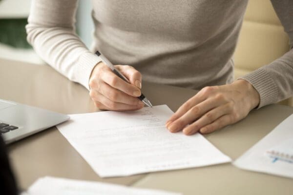 A woman signing some paperwork