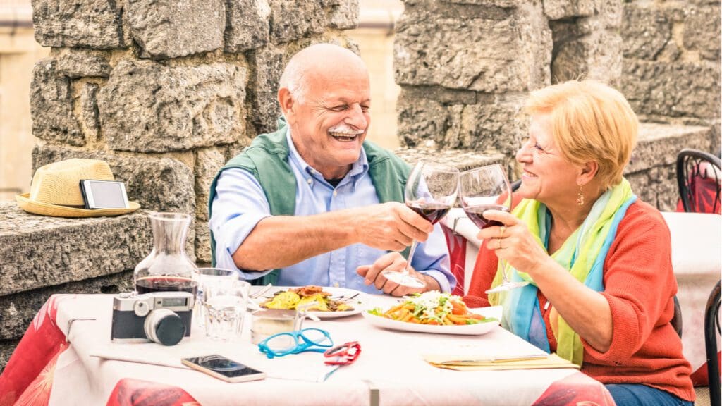 An older couple eating at a restaurant while on holiday.